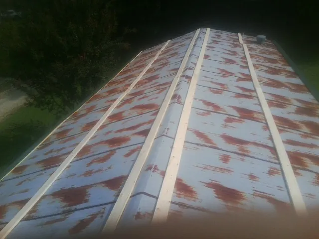 Rusted metal roof panels with new wood purlins before replacement — Storm Damage Roof Repair in Muskegon by Roofing Brothers