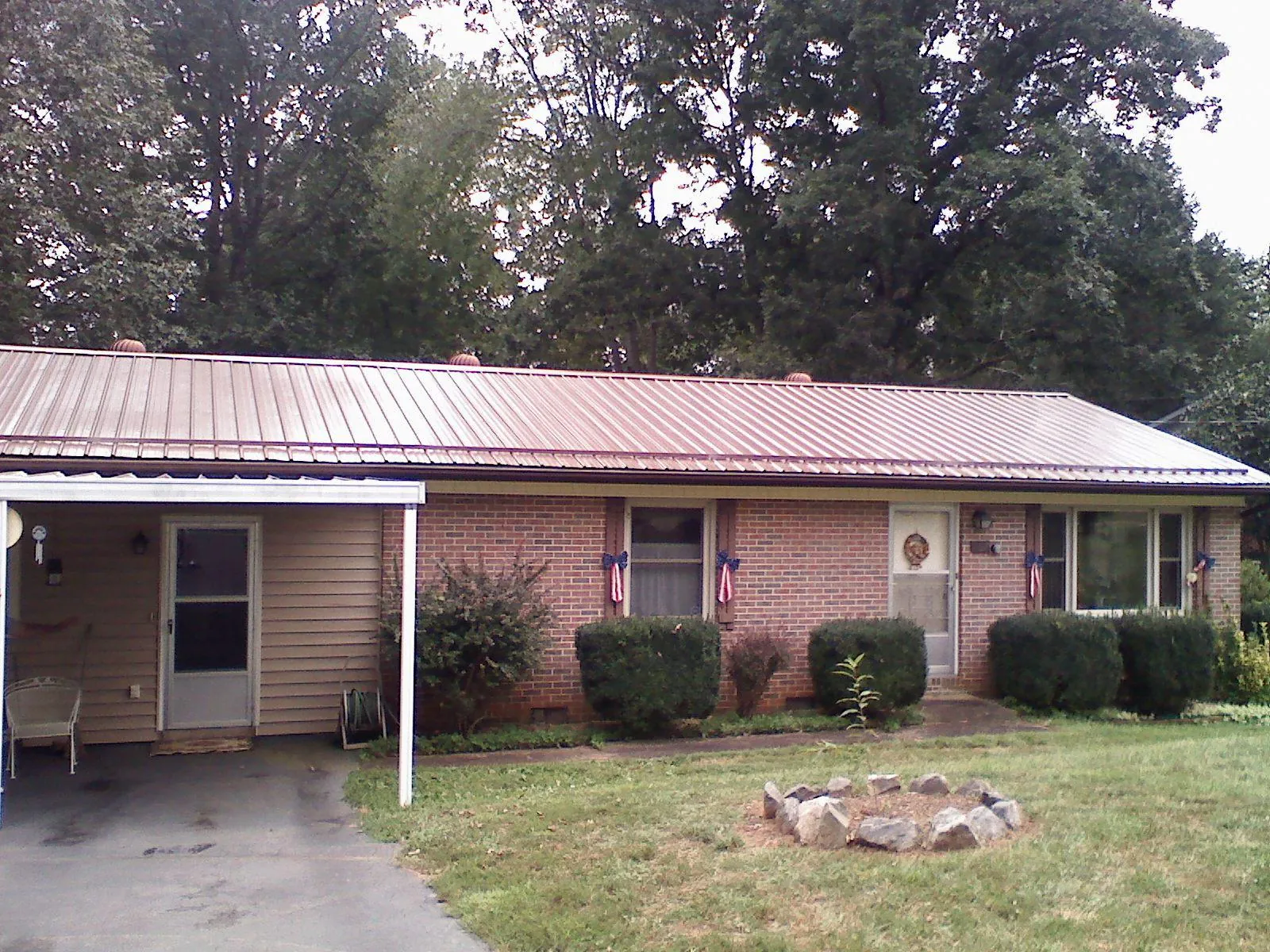 Bronze metal roof and carport on a brick ranch home — Roof Repair work by our crew in Muskegon
