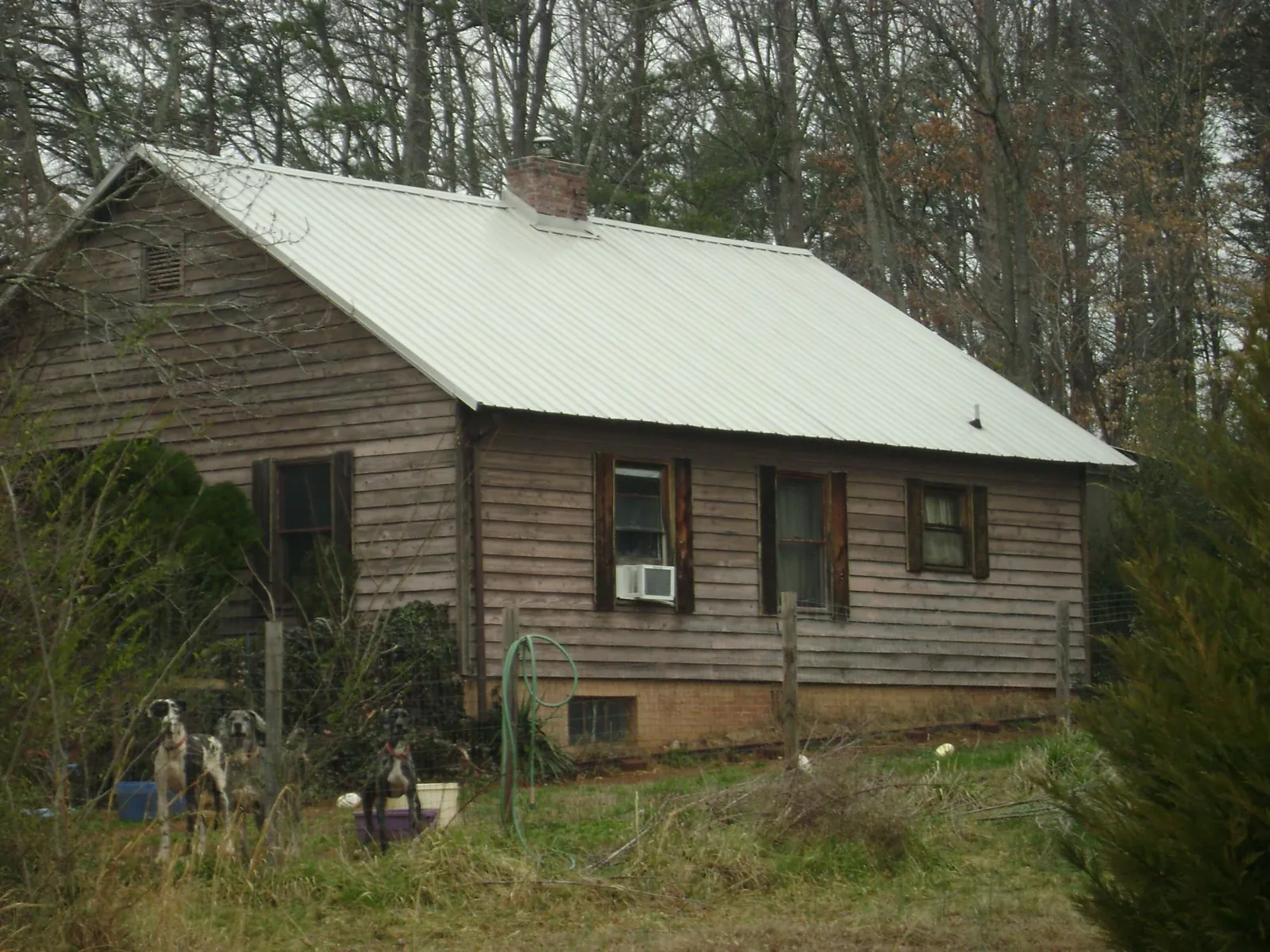 White metal roof on an old wood sided farmhouse, from a Metal Roof Installation job in Muskegon